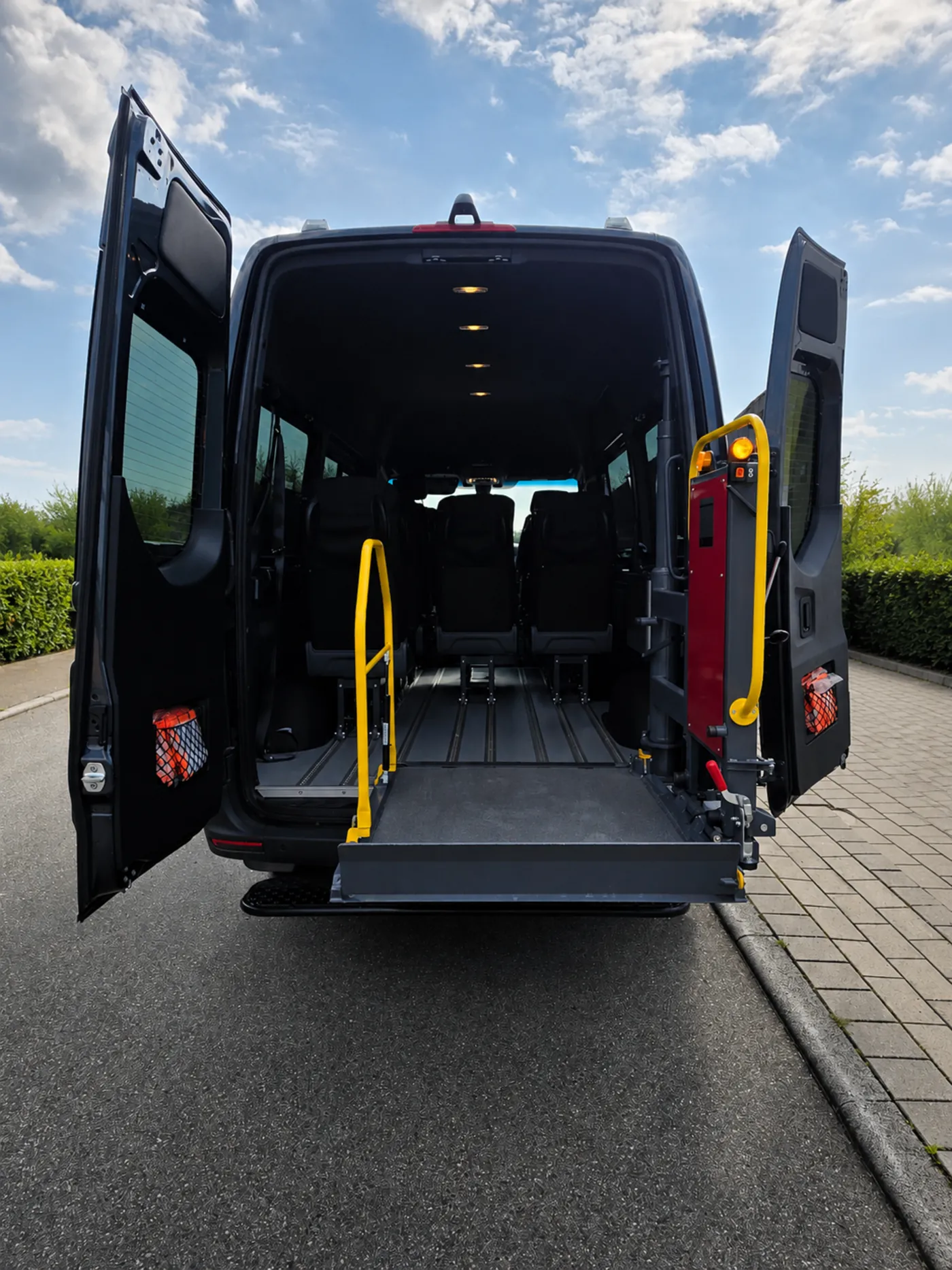 Heck des Rollstuhl-Taxis mit geöffneten Flügeltüren und heruntergelassener Auffahrt